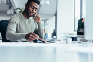 Businessman talking on smartphone and working in office.