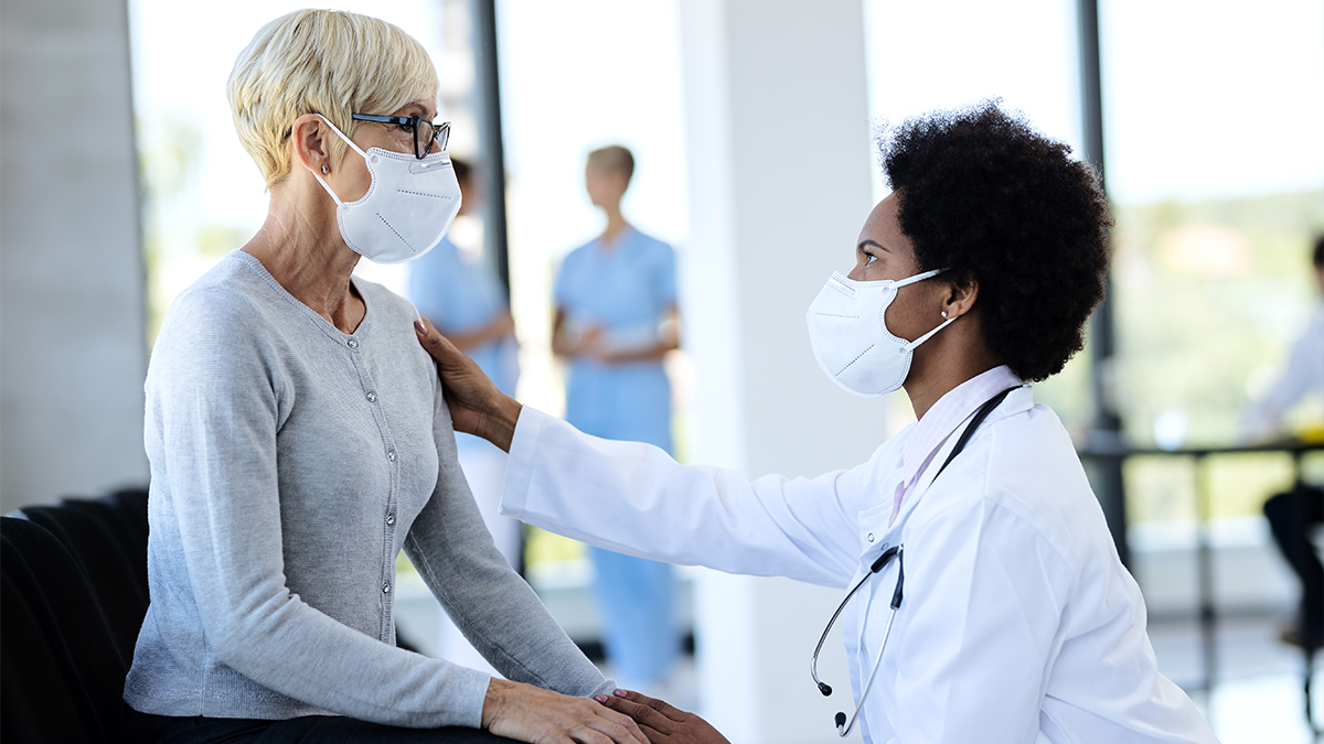 doctor talking to patient wearing protective face mask