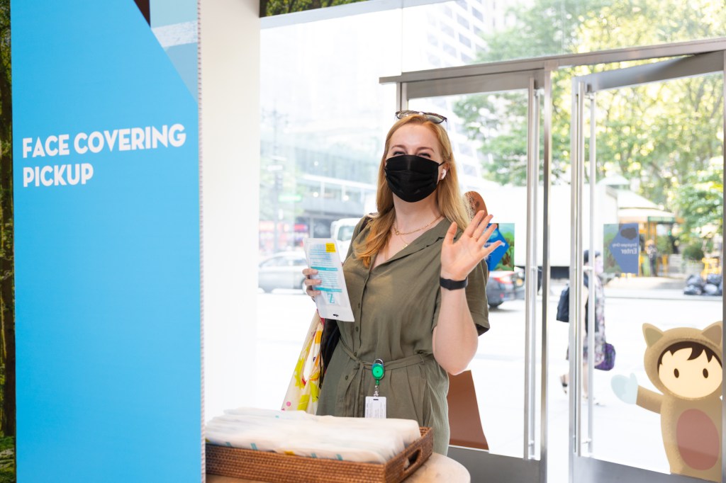 An employee retrieving a face covering in the lobby of Salesforce Tower New York