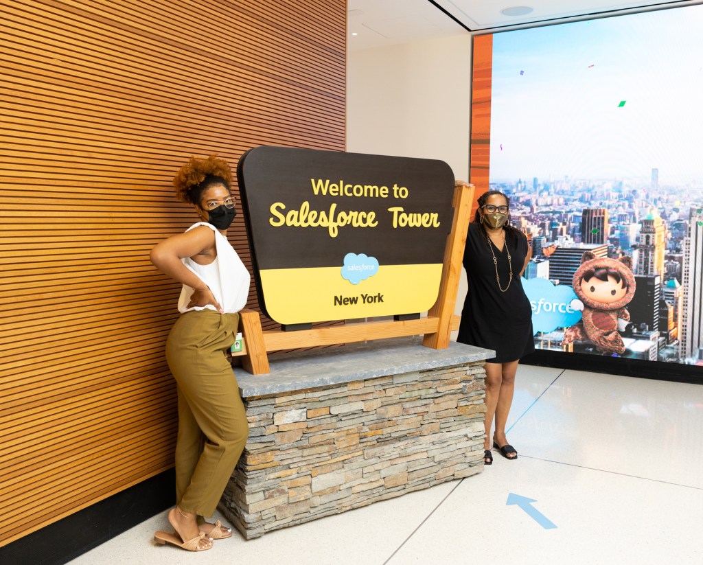 Employees in front of the Salesforce Tower New York lobby sign