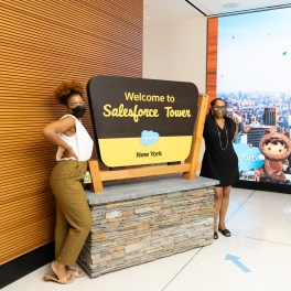 Employees in front of the Salesforce Tower New York lobby sign