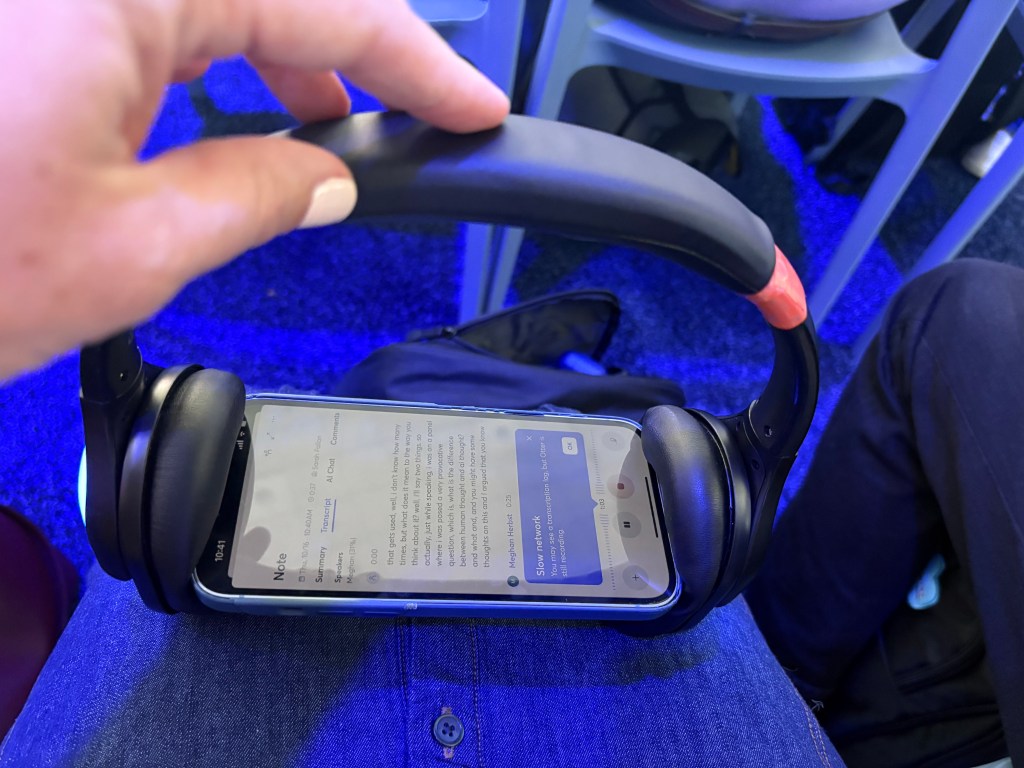 Image of headphones placed around someone's smart phone to capture session audio.