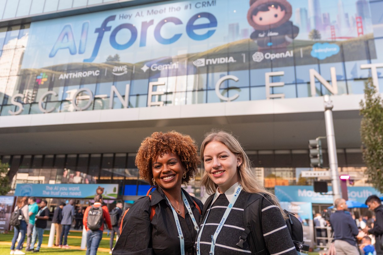 Dreamforce 2026 attendees smile for a picture in front of Moscone Center.