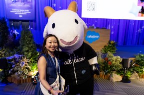 An attendee poses with Cloudy the Goat before a keynote.
