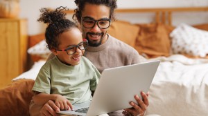 Vader en dochter bekijken laptop