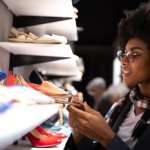 Vrouw kijkt naar een paar schoenen in de winkel