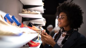 Vrouw kijkt naar een paar schoenen in de winkel