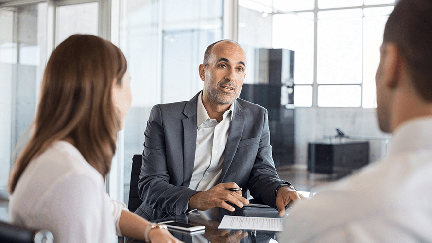 Man sits with his customers at a table