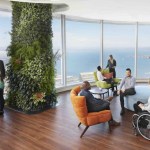 Several people are standing and seated in an open lounge in Salesforce’s San Francisco headquarters. This shows that Salesforce is making its spaces accessible for all.